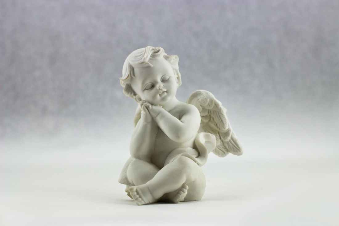 white ceramic figurine of angel illustration
