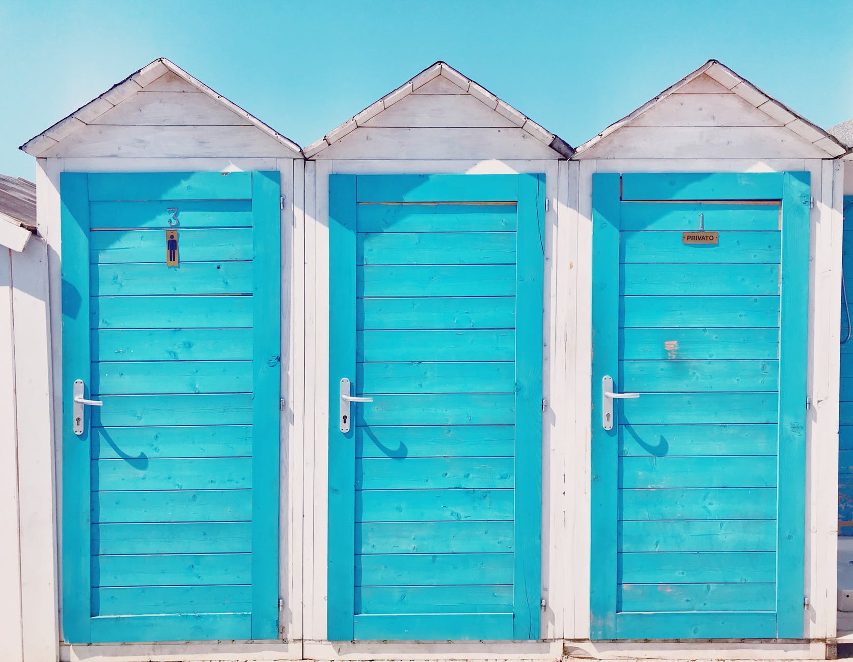 photo of three wooden toilets