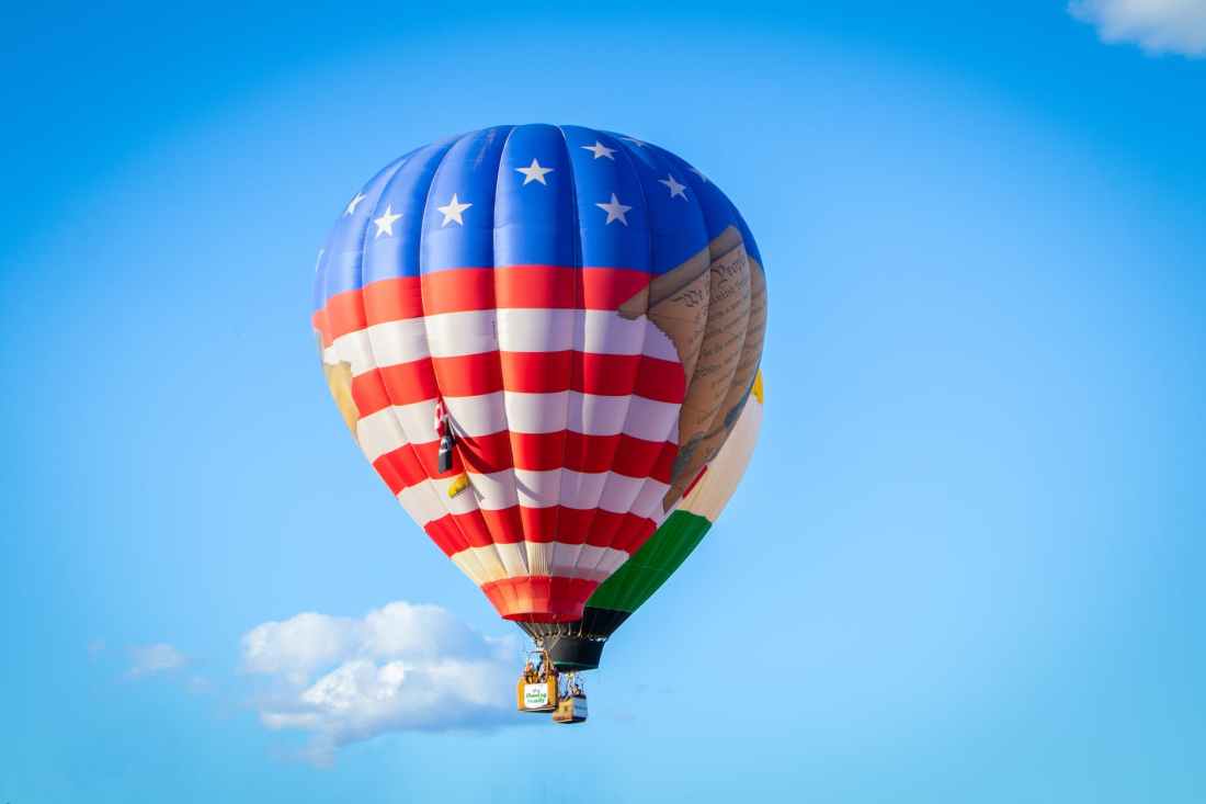 white red and blue hot air balloon flying