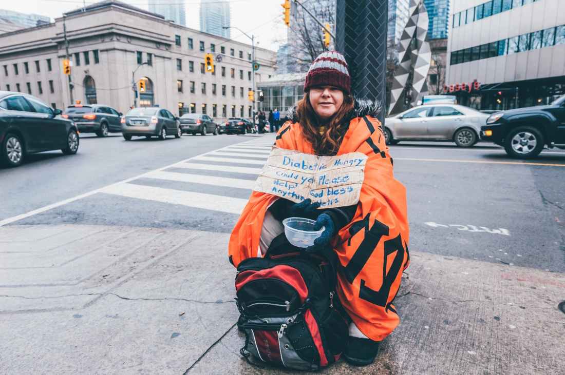 photo of woman sitting on sidewalk