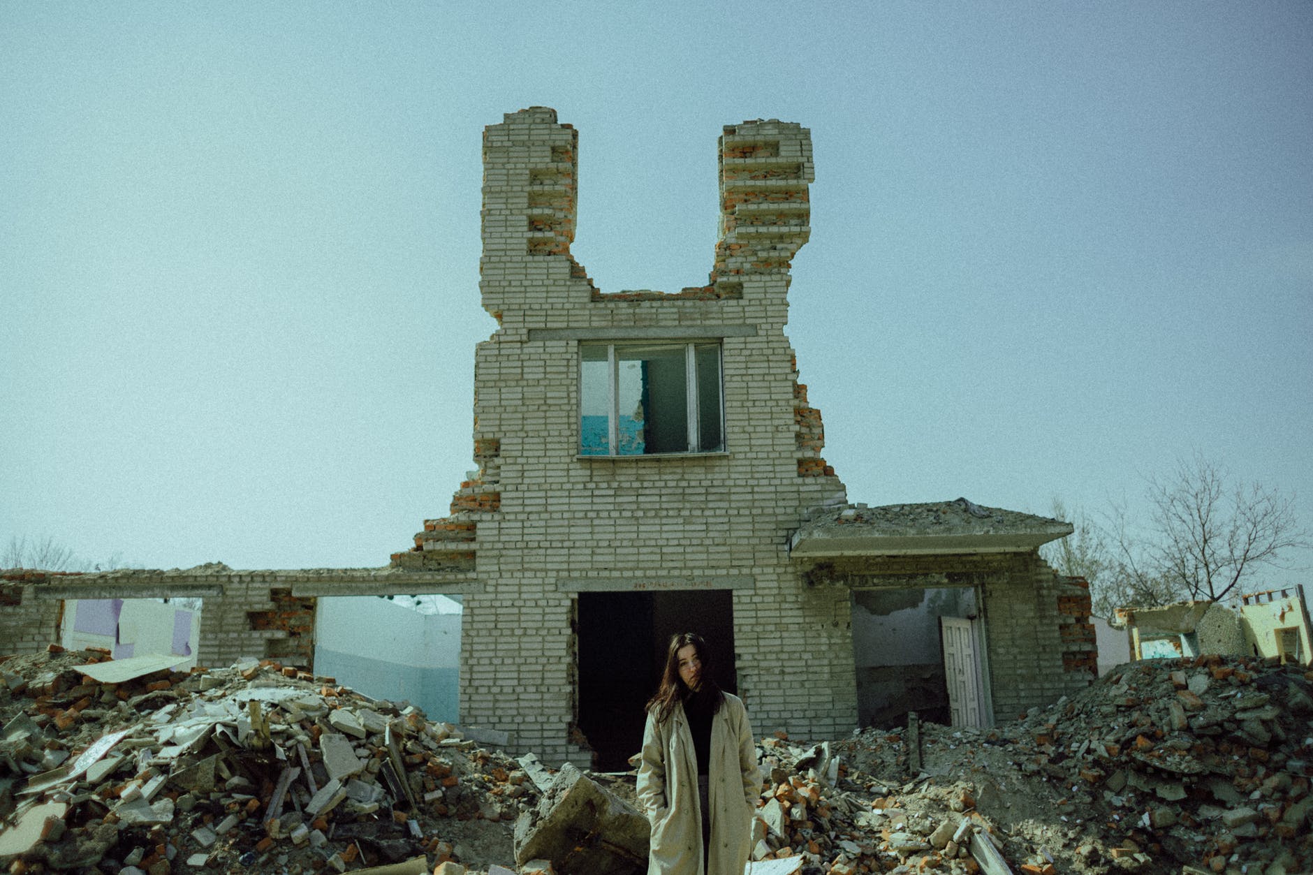 woman standing near a demolished concrete building