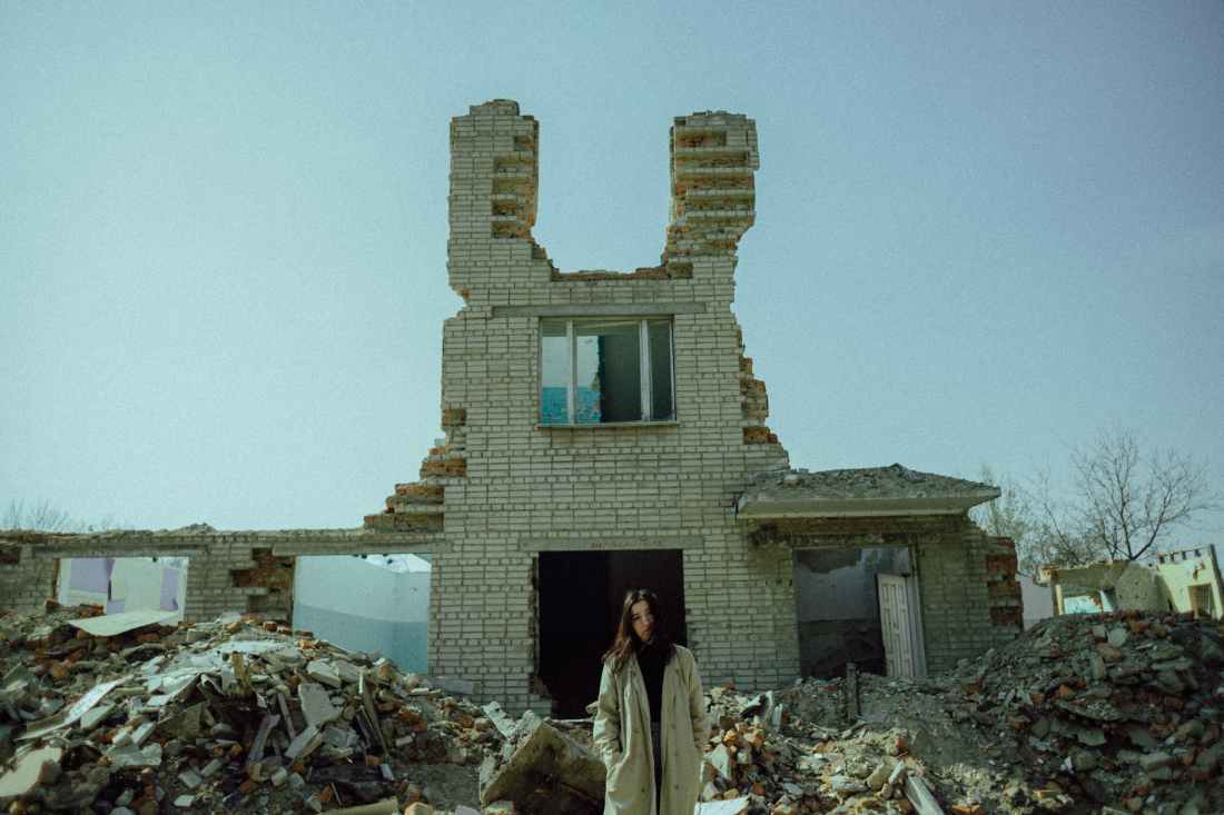 woman standing near a demolished concrete building